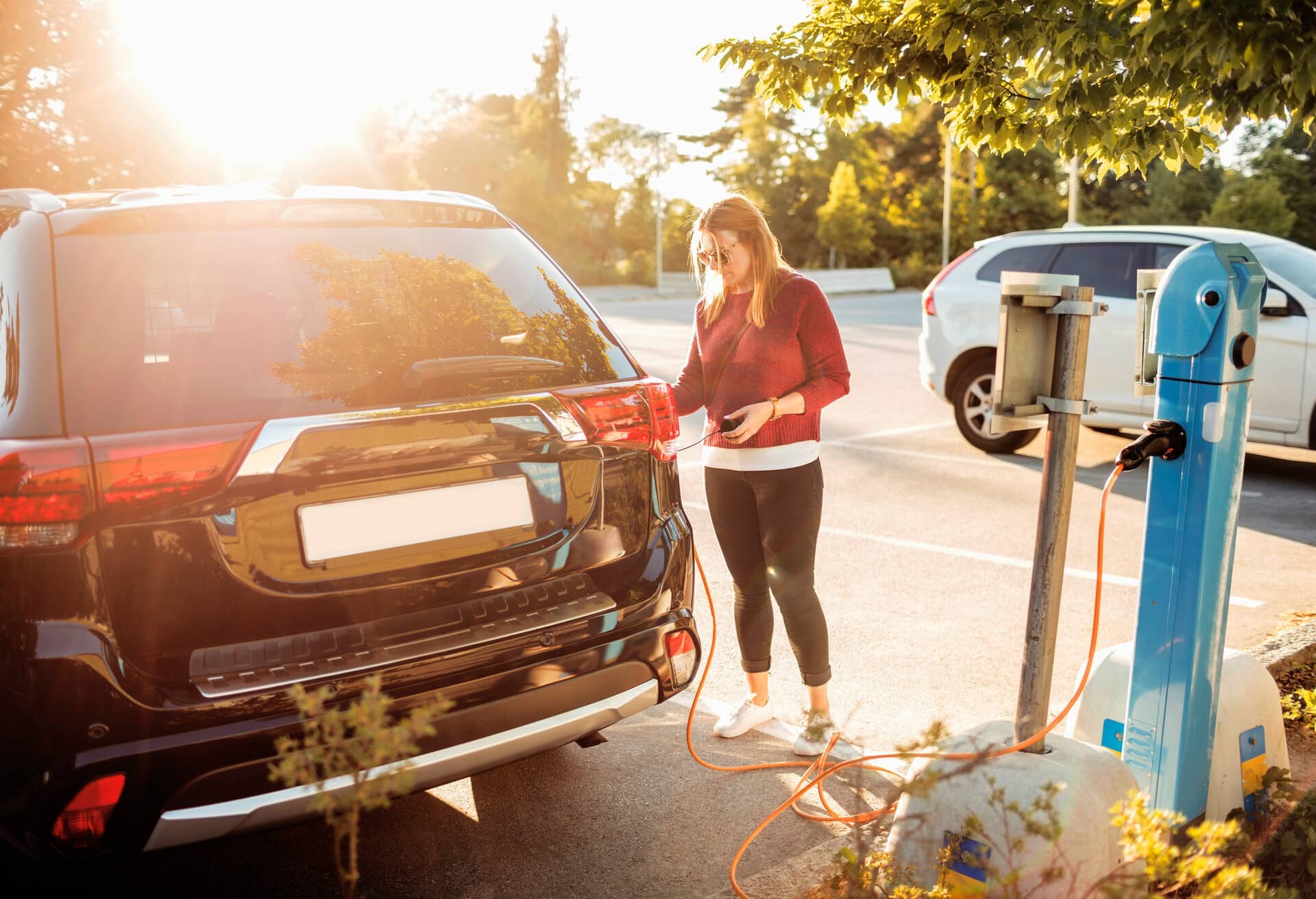 Dziewczyna ładująca samochód elektryczny.