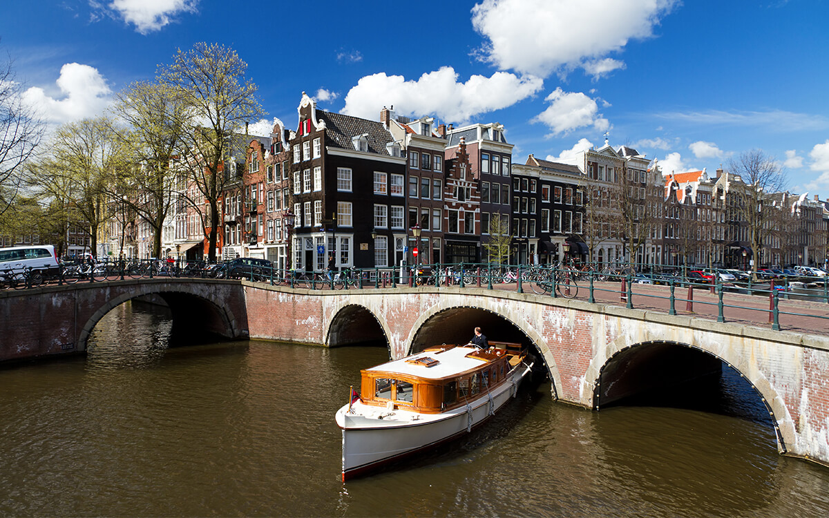 Łódka przepływająca pod mostem w Amsterdamie