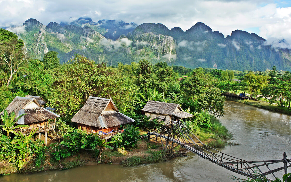 Wioska, buja zieleń i drewniane chatki, Laos