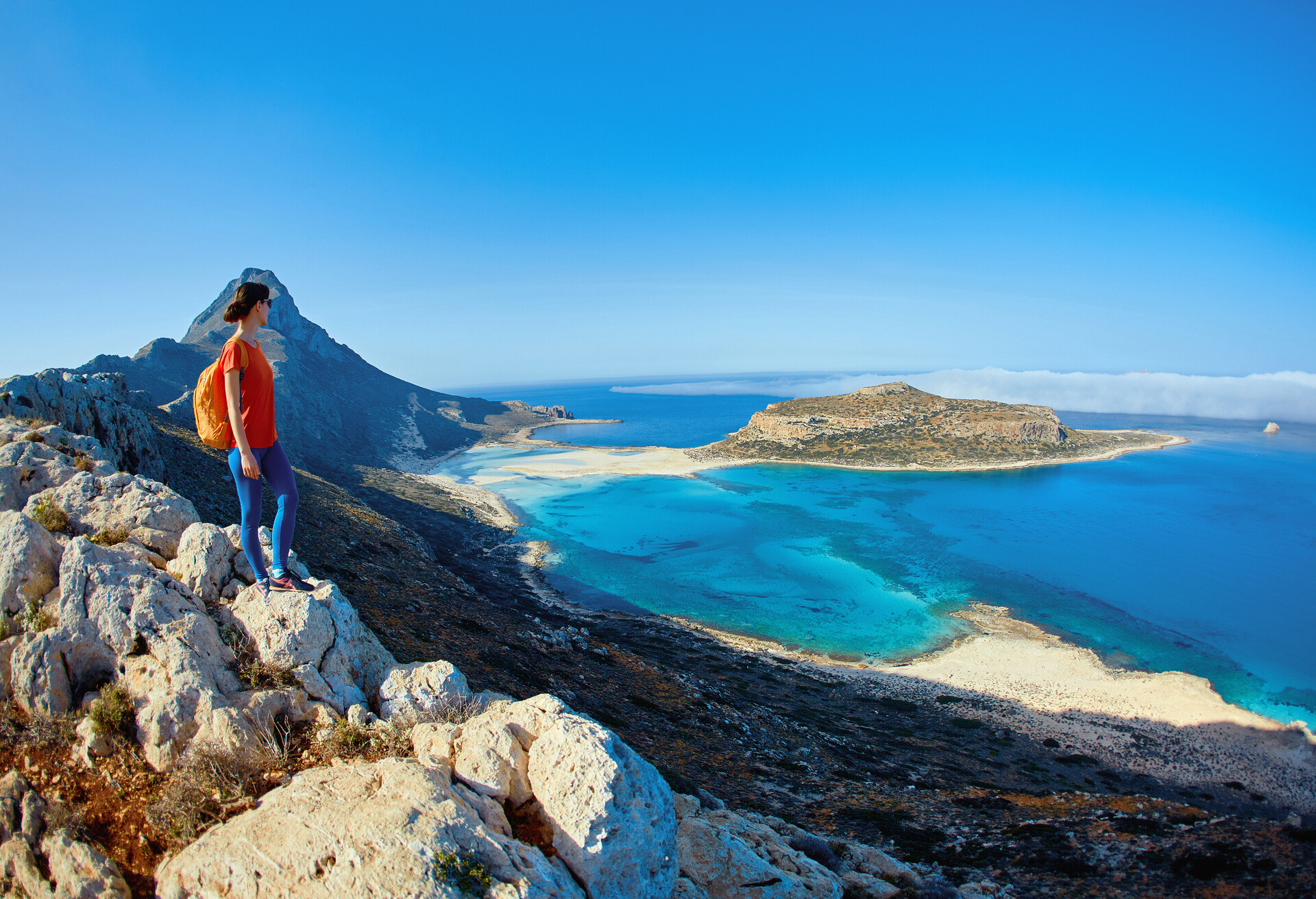panoramic view on Balos beach, Crete, Greece. Woman, traveller stands on the cliff against sea background; Shutterstock ID 446003965; Brand (KAYAK, Momondo, Any): any